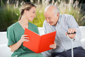 caregiver and senior woman reading book