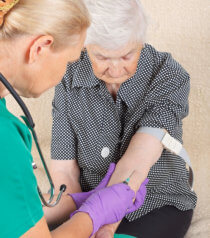 phlebotomist drawing blood from patient