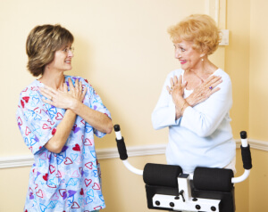 caregiver assisting senior woman in therapy